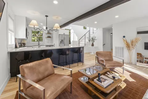 a living room with furniture and view of kitchen