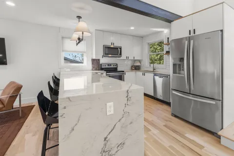 a kitchen with stainless steel appliances granite countertop a refrigerator stove microwave and sink