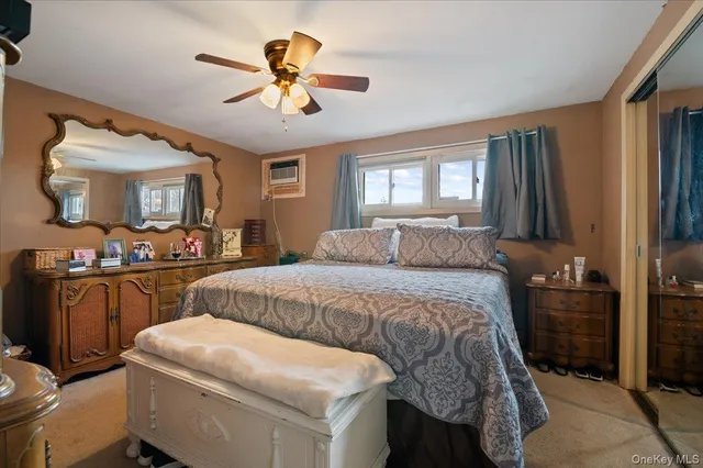 a bedroom with a bed and a dresser with mirror