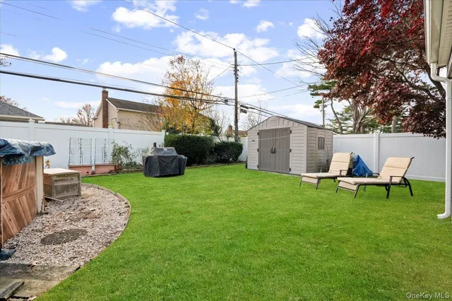 a view of a white house with a chairs in a patio