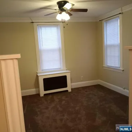 an empty room with windows and fan