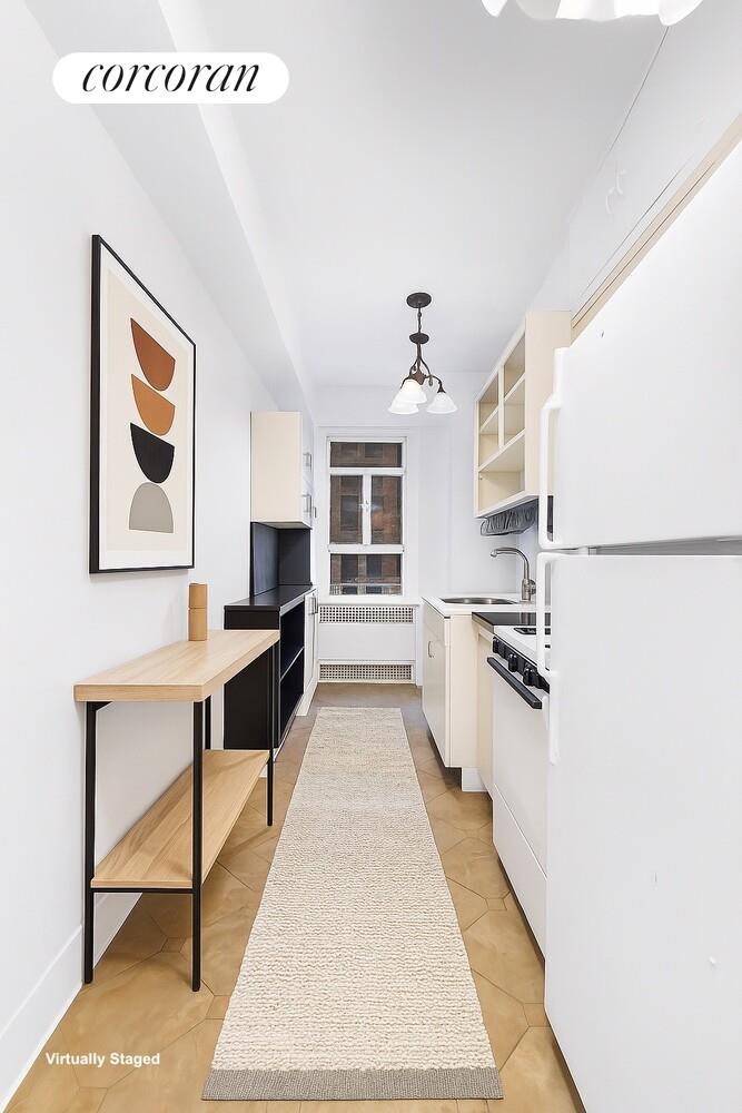 19 East 88th Street, Unit 4H Manhattan, NY 10128 - Photo 5 of 12 a large white kitchen with stainless steel appliances granite countertop a sink and a stove