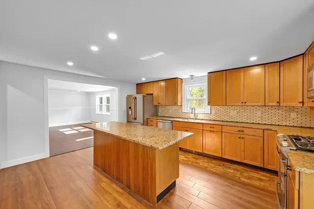 a large kitchen with stainless steel appliances granite countertop a large window and a sink
