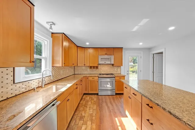 a bathroom with a granite countertop sink a mirror and shower
