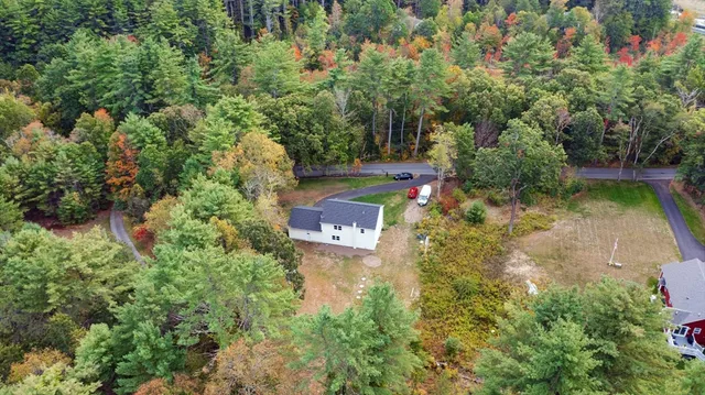 an aerial view of residential house with outdoor space and trees all around