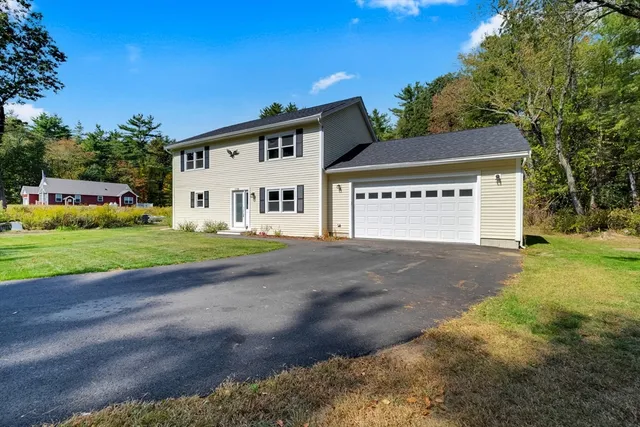 a view of a house with a yard and garage