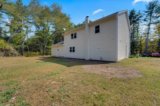 a view of a house with backyard and trees