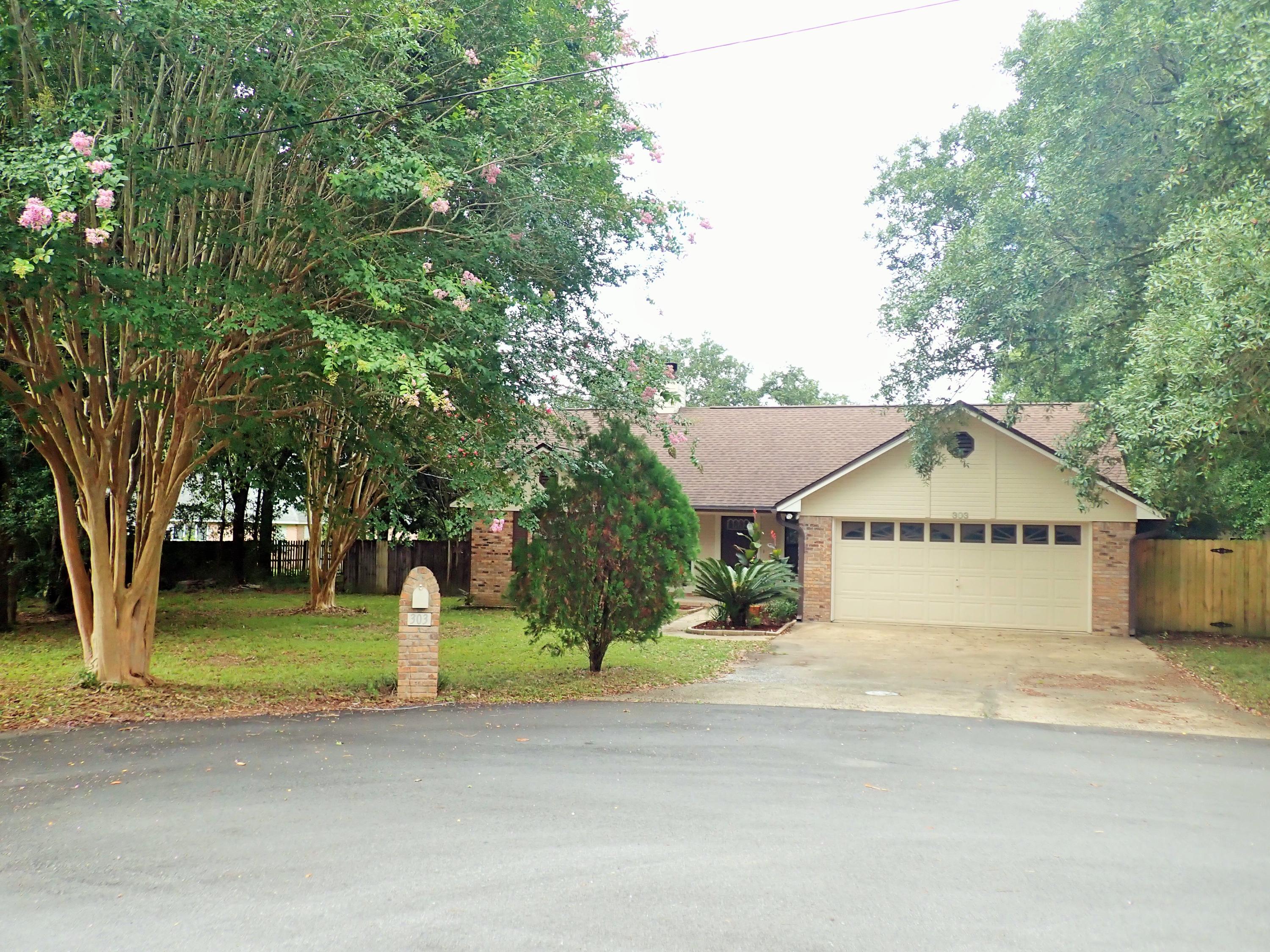303 Sheldon Court Crestview, FL 32539 - Photo 2 of 45 a front view of a house with a yard and garage