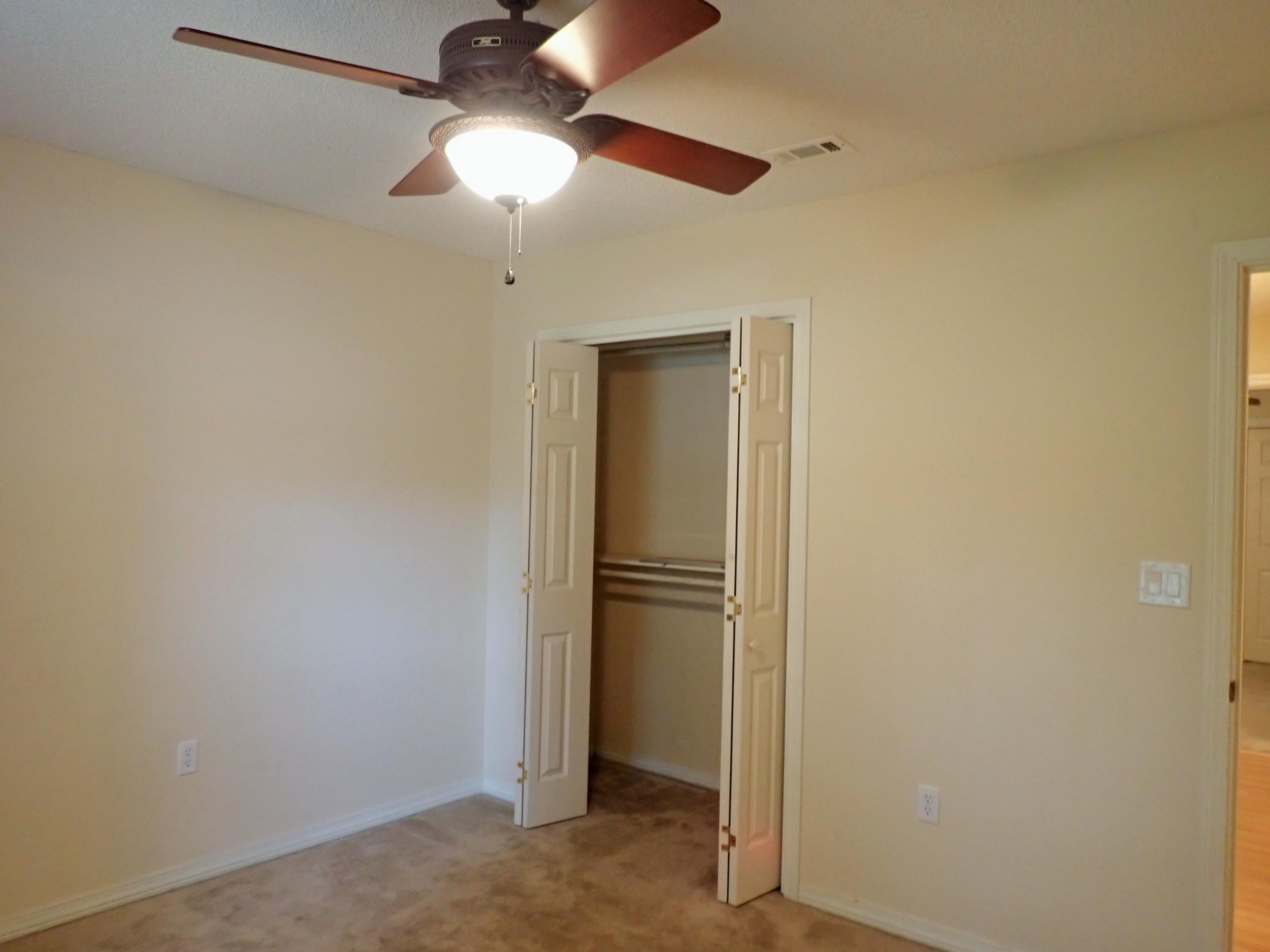 303 Sheldon Court Crestview, FL 32539 - Photo 21 of 45 an empty room with closet and a chandelier fan