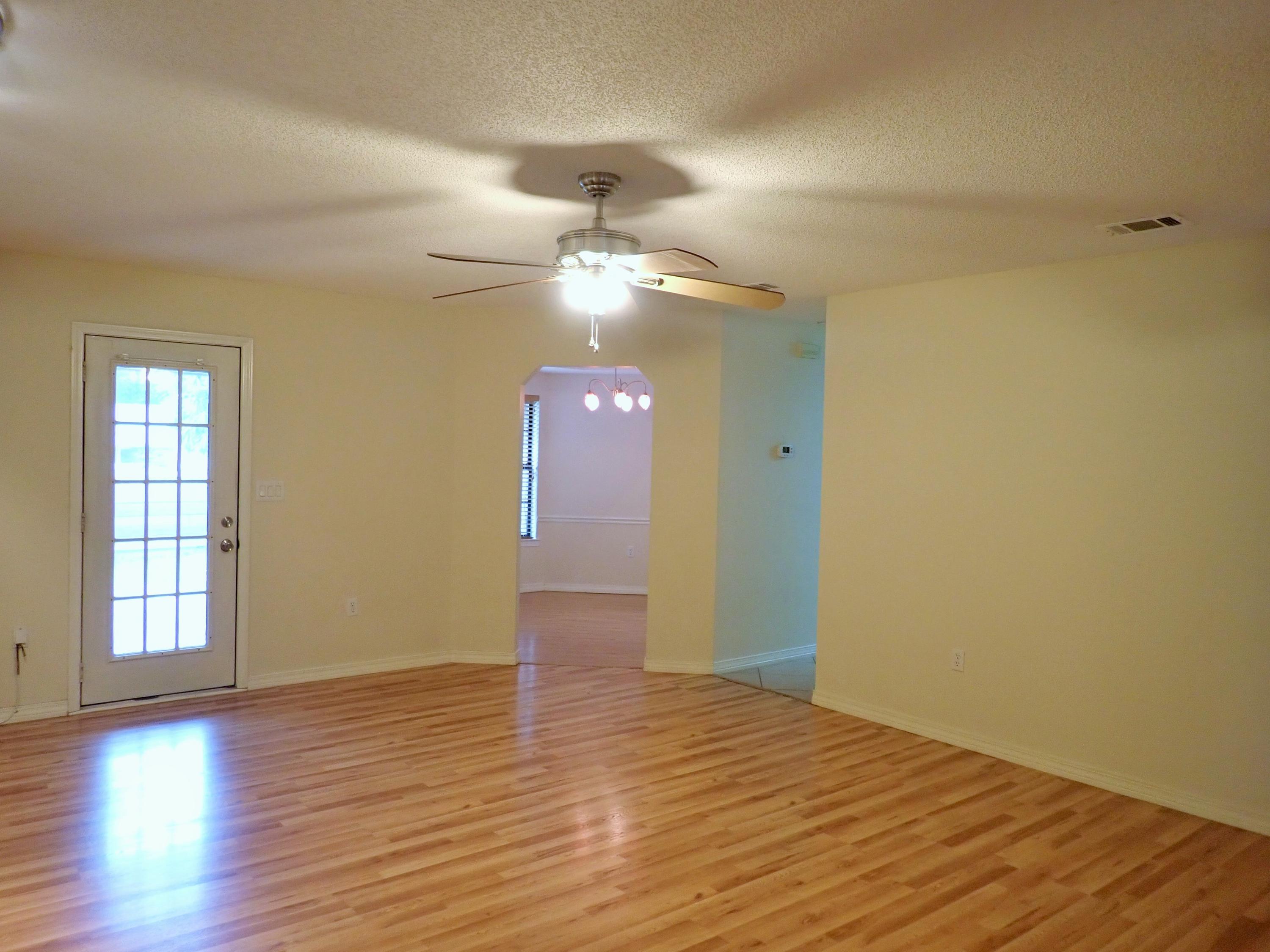 303 Sheldon Court Crestview, FL 32539 - Photo 6 of 45 wooden floor in an empty room with a window