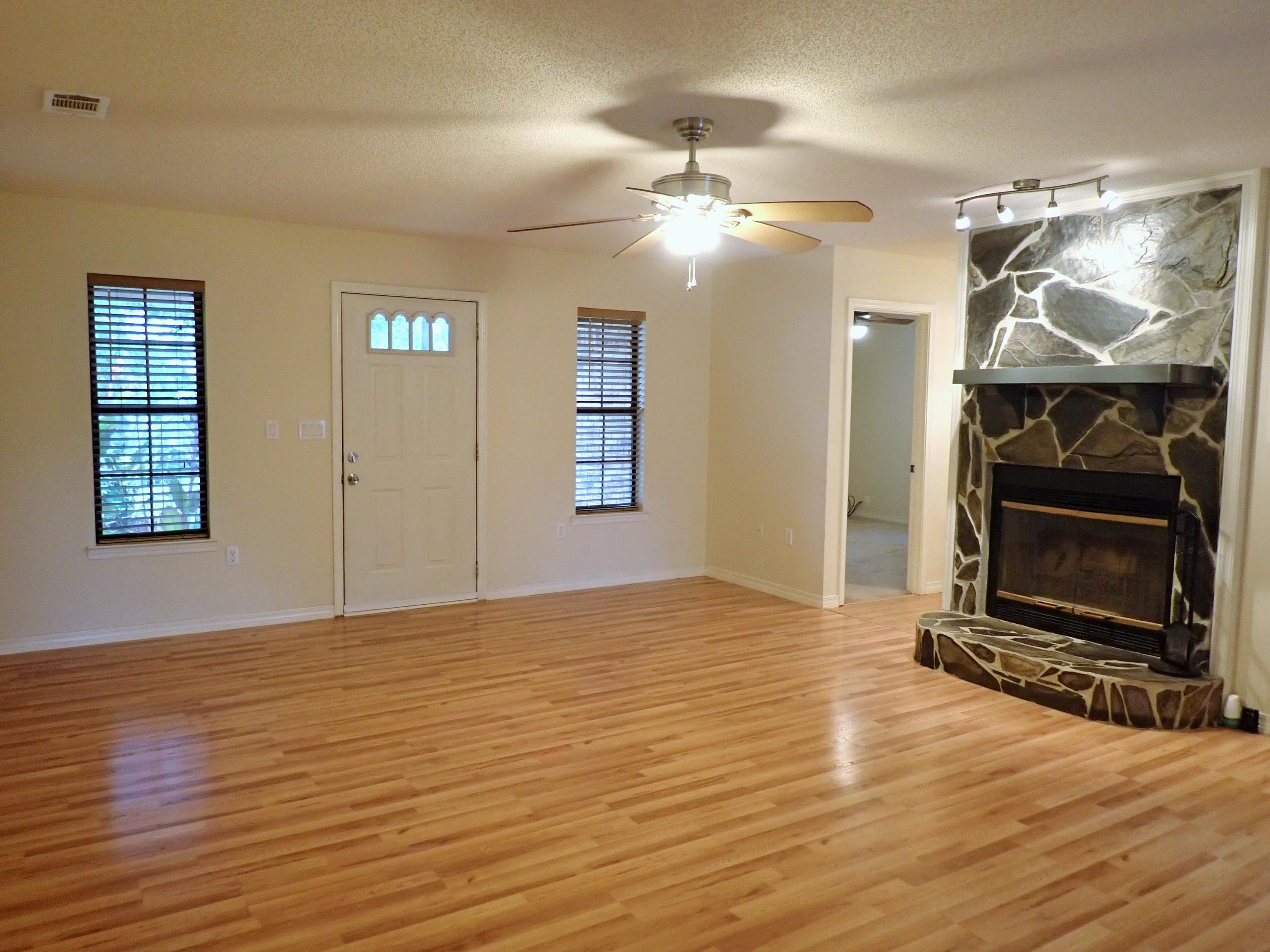 303 Sheldon Court Crestview, FL 32539 - Photo 7 of 45 a view of an empty room with wooden floor and a fireplace
