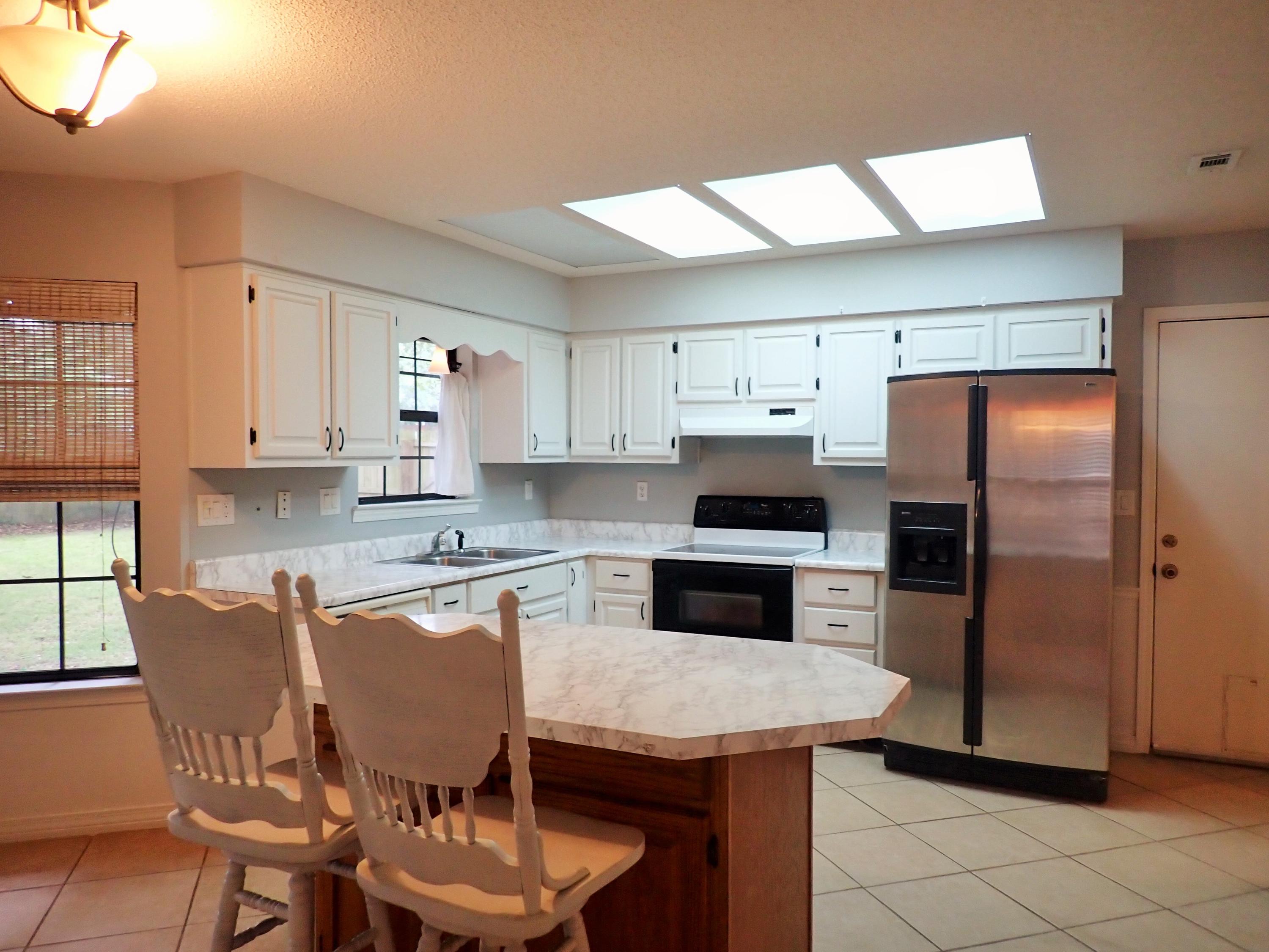 303 Sheldon Court Crestview, FL 32539 - Photo 10 of 45 a kitchen with stainless steel appliances granite countertop a kitchen island hardwood floor sink and stove