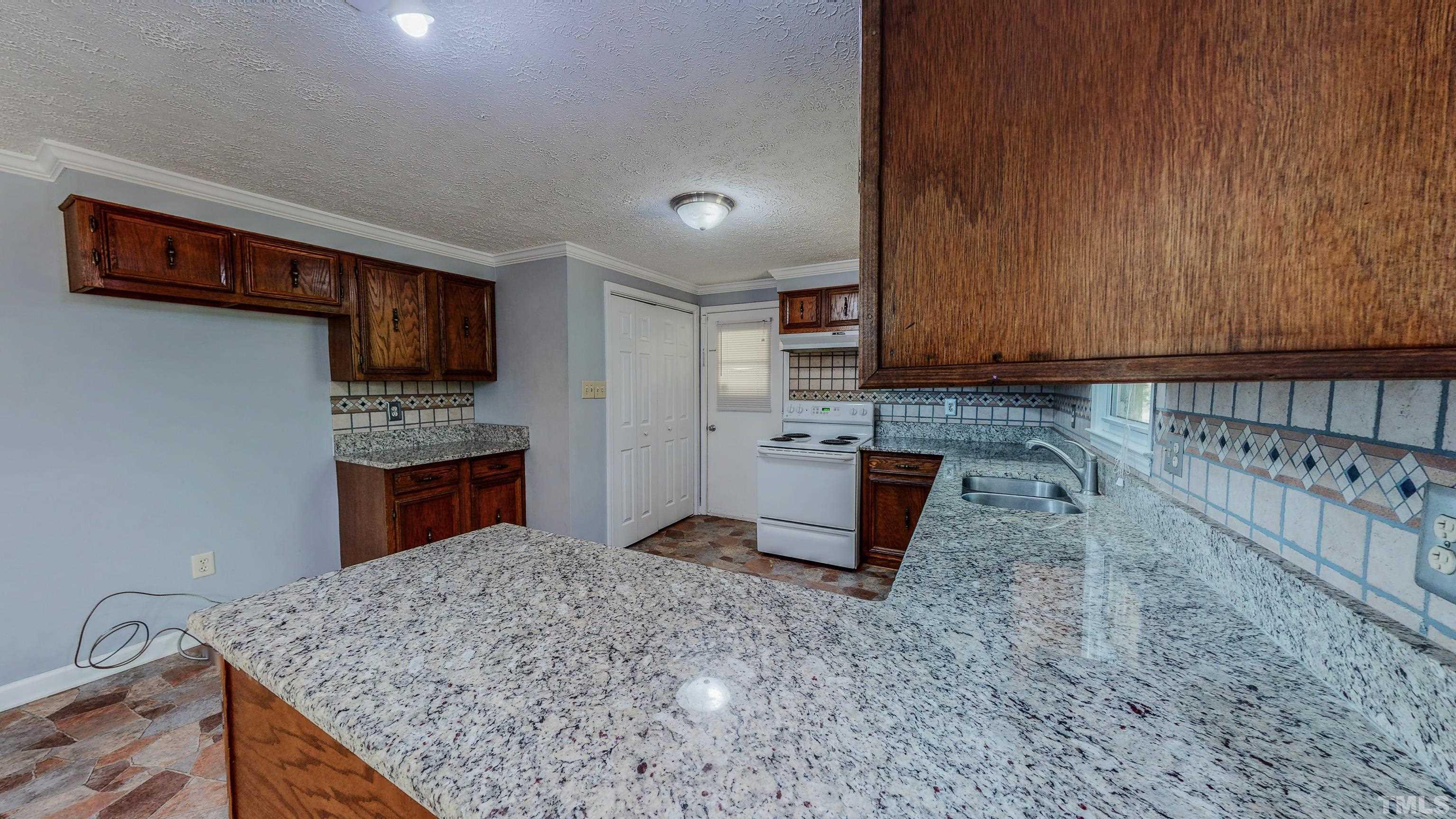 180 Dancy Day Road Roxboro, NC 27574 - Photo 13 of 30 a kitchen with stainless steel appliances granite countertop a sink stove and refrigerator