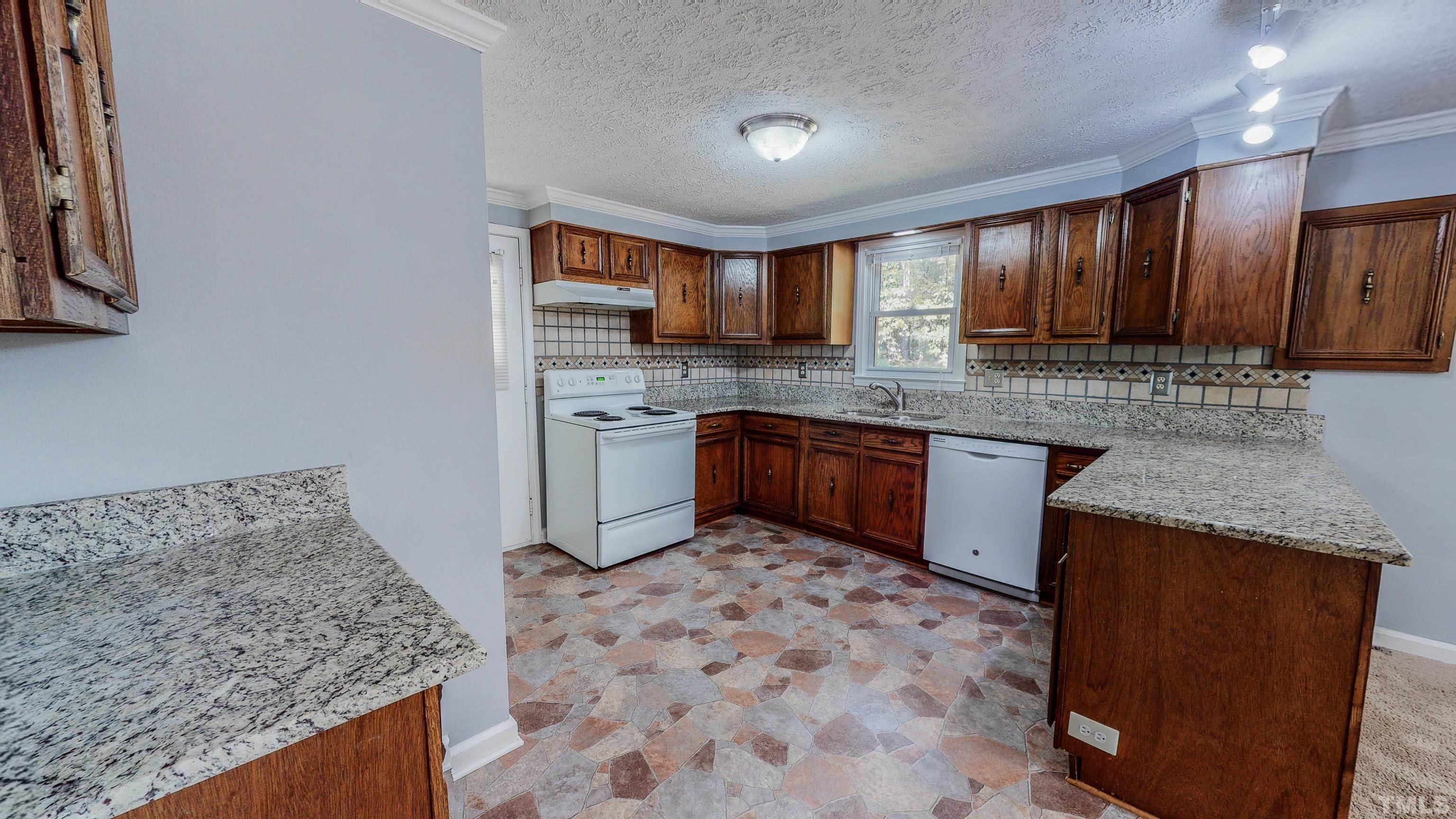 180 Dancy Day Road Roxboro, NC 27574 - Photo 3 of 30 a kitchen with stainless steel appliances granite countertop a sink stove and refrigerator
