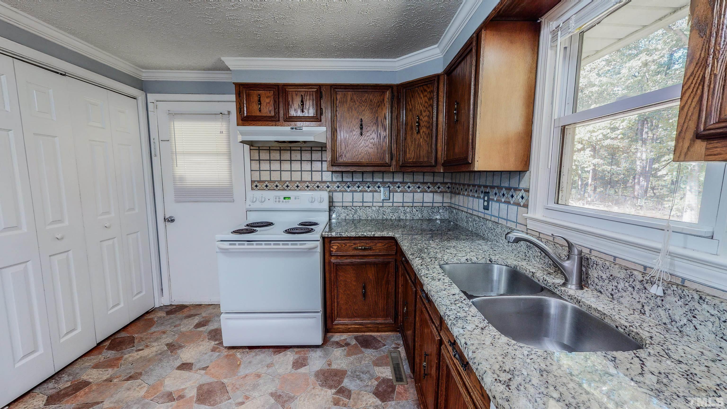 180 Dancy Day Road Roxboro, NC 27574 - Photo 9 of 30 a kitchen with a sink stove top oven and cabinets
