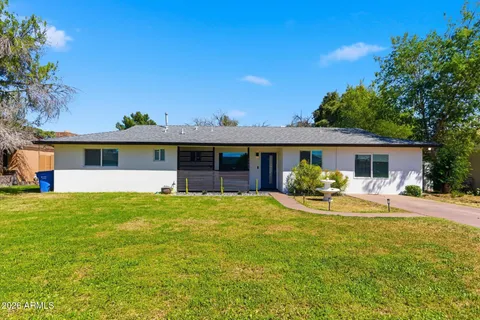 a front view of a house with a garden and yard