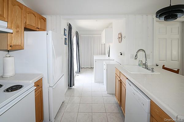 14 Lincoln Road Hampton Bays, NY 11946 - Photo 17 of 34 a kitchen with a sink a refrigerator and cabinets