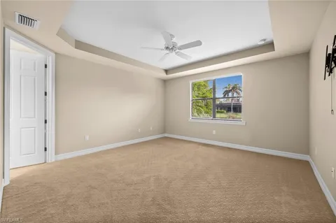 an empty room with windows and ceiling fan