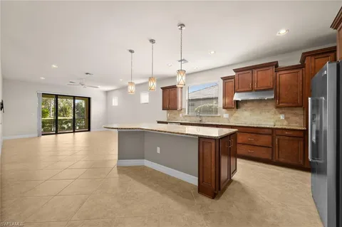 a large kitchen with kitchen island granite countertop a large counter top a sink stainless steel appliances and cabinets