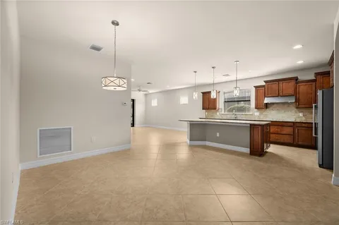 a large kitchen with a counter space a sink appliances and cabinets