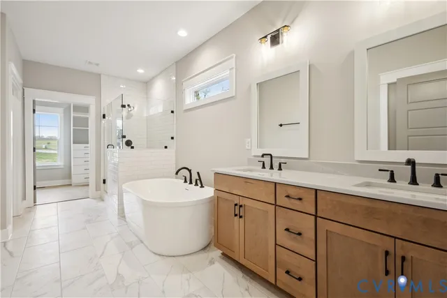 a spacious bathroom with a double vanity sink mirror and bathtub