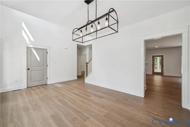a view of a room with wooden floor and white walls