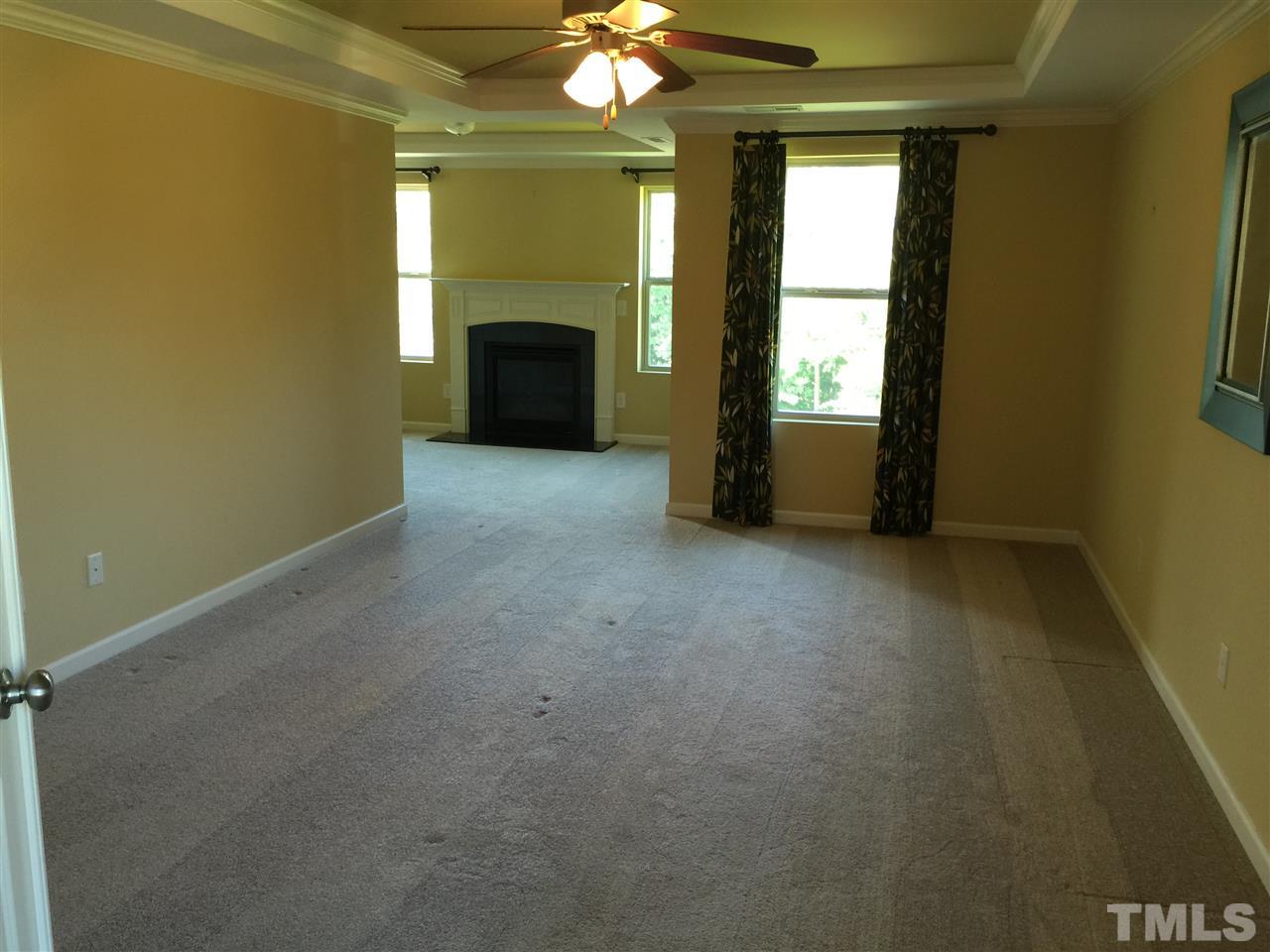 1314 Ranchester Road Knightdale, NC 27545 - Photo 15 of 25 an empty room with a fireplace and windows