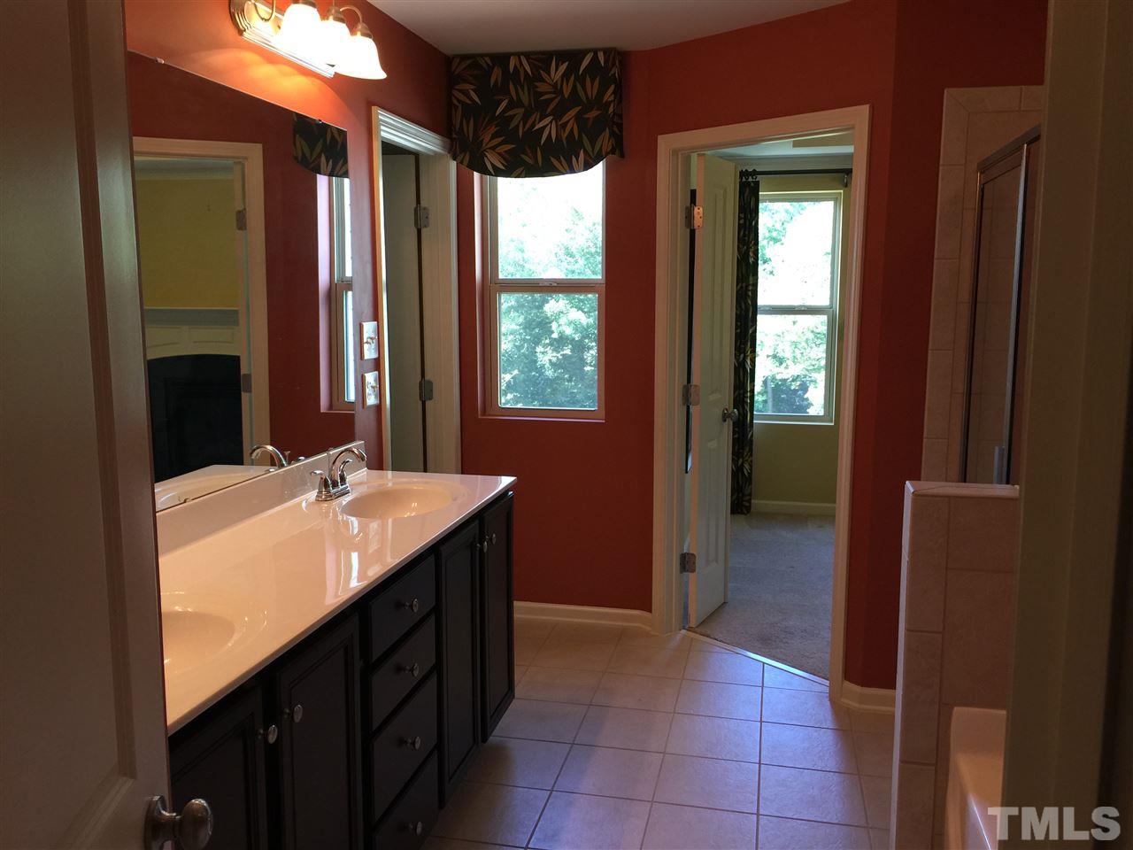 1314 Ranchester Road Knightdale, NC 27545 - Photo 20 of 25 a bathroom with a double vanity sink a mirror and a bathtub