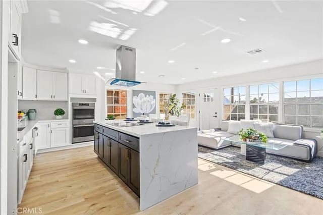 a kitchen with a stove cabinets and living room view