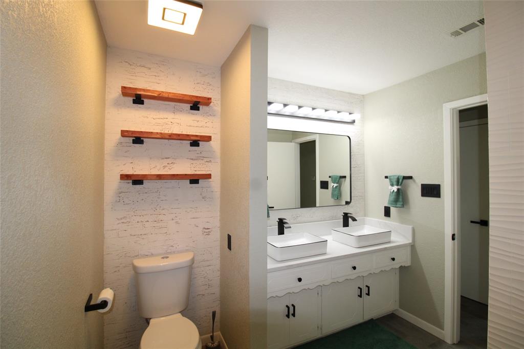 818 East Clinton Avenue Athens, TX 75751 - Photo 14 of 24 a bathroom with a toilet sink and mirror