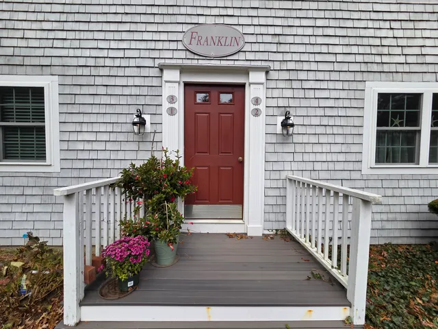 a front view of a house with a potted plant