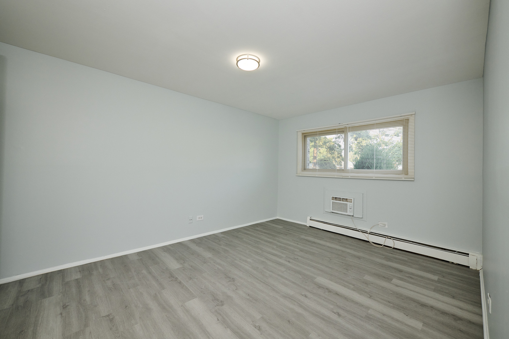 1320 Lore Lane, Unit 101A Lombard, IL 60148 - Photo 40 of 65 an empty room with wooden floor and windows