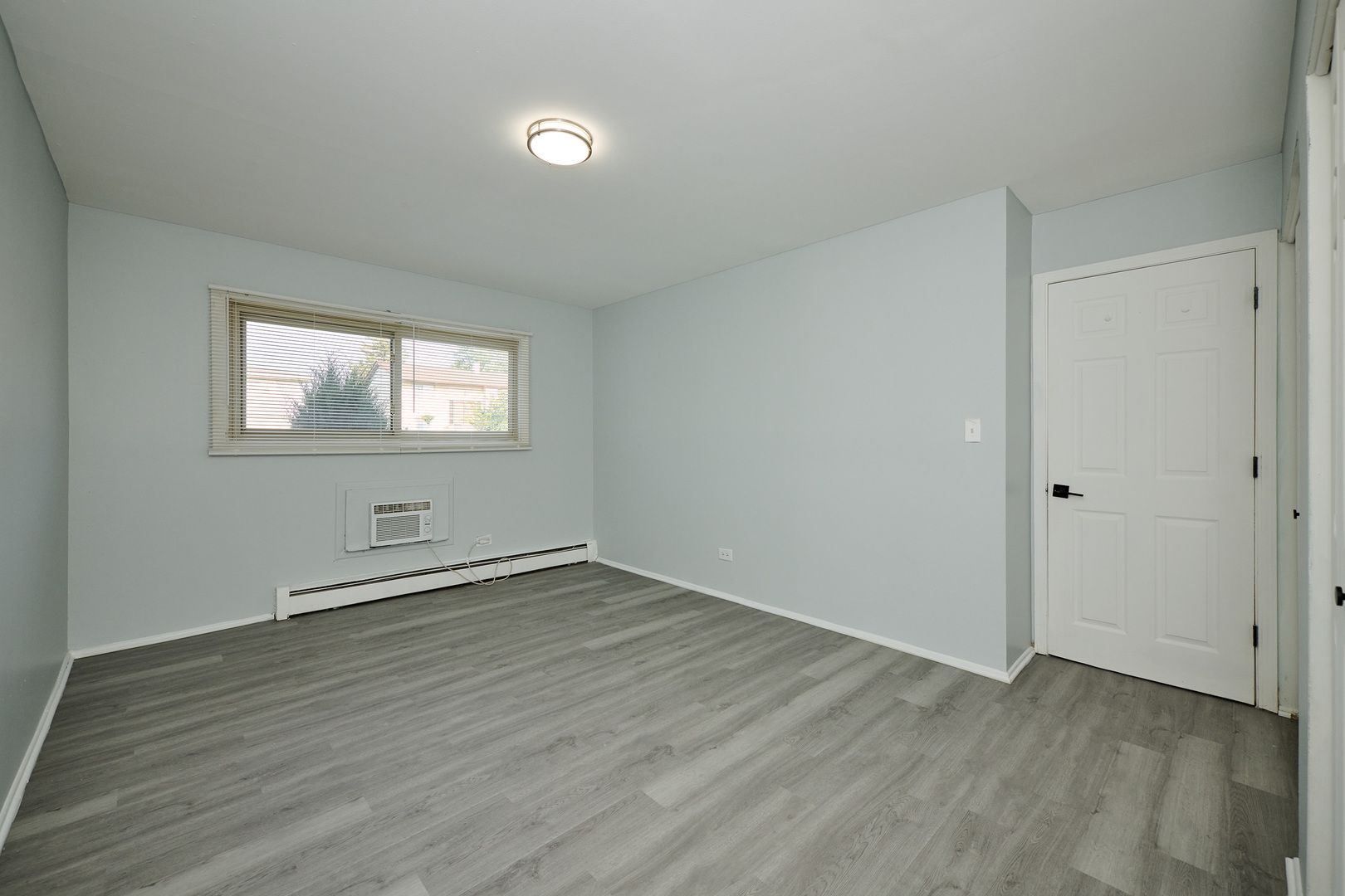 1320 Lore Lane, Unit 101A Lombard, IL 60148 - Photo 48 of 65 an empty room with wooden floor and windows
