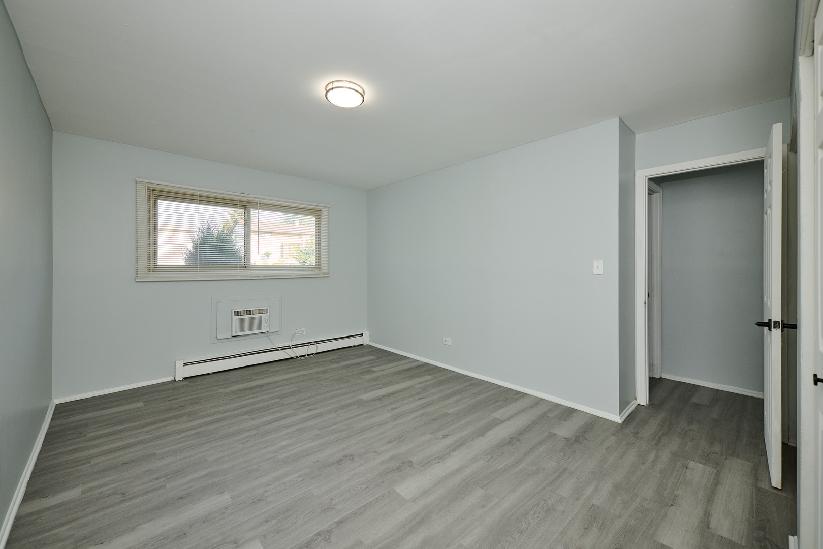 1320 Lore Lane, Unit 101A Lombard, IL 60148 - Photo 49 of 65 an empty room with wooden floor and windows