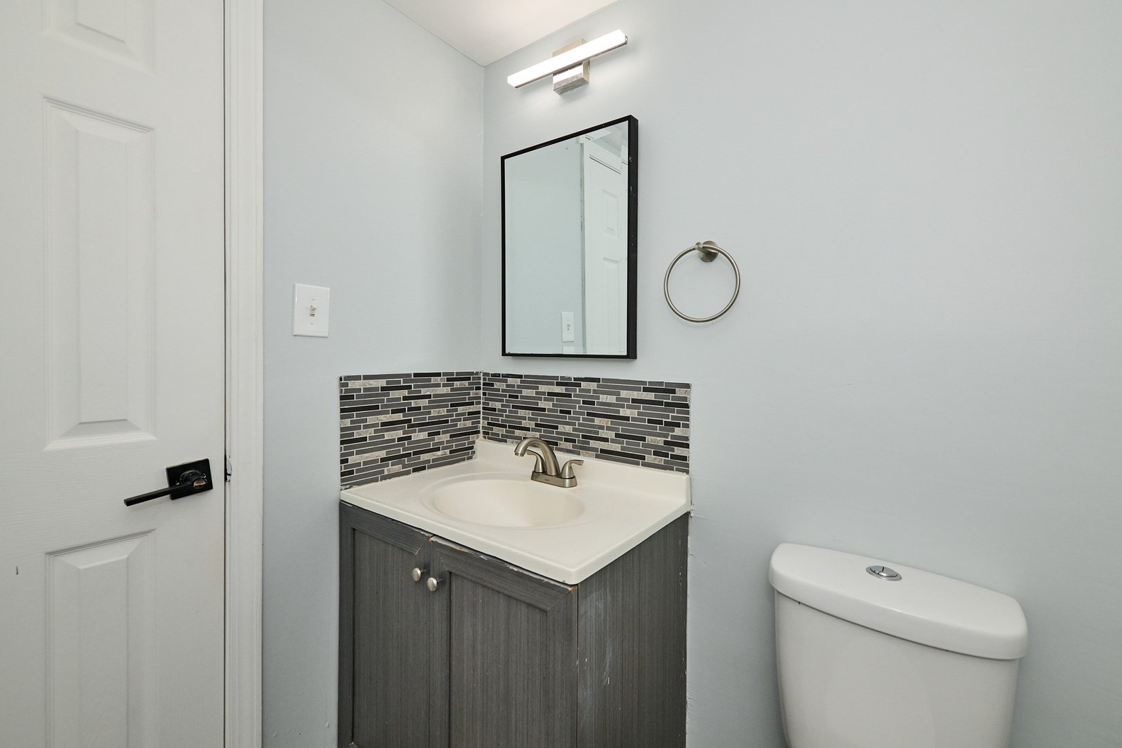1320 Lore Lane, Unit 101A Lombard, IL 60148 - Photo 52 of 65 a bathroom with a toilet sink vanity and mirror