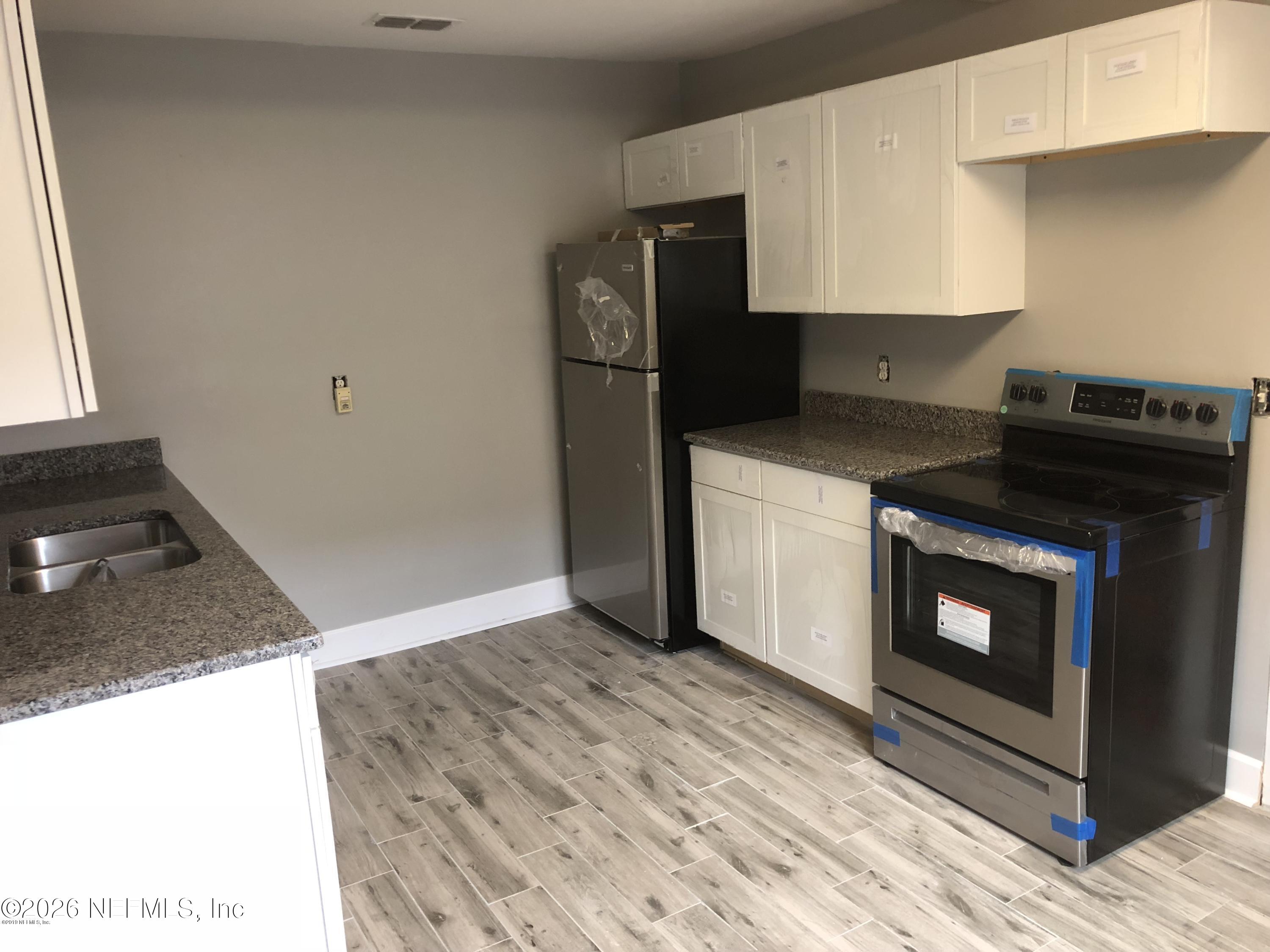 925 Phillips Street, Unit 3 Jacksonville, FL 32207 - Photo 3 of 10 a kitchen with a stove and a refrigerator