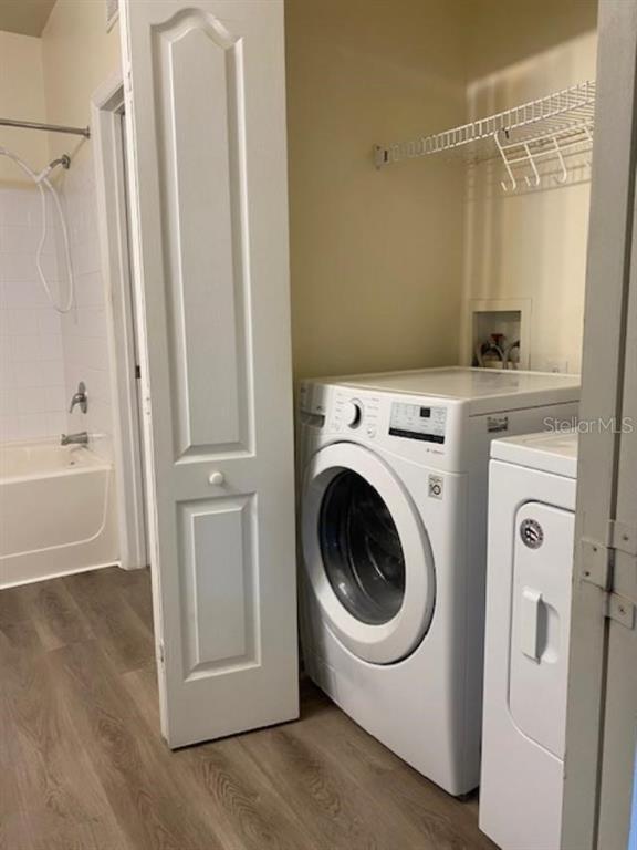 8849 Villa View Circle, Unit 203 Orlando, FL 32821 - Photo 6 of 20 a utility room with wooden floor washer and dryer