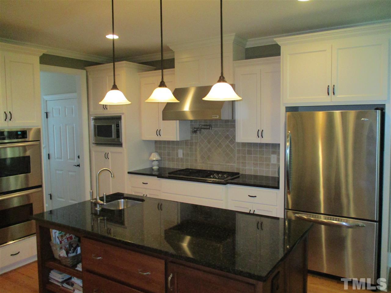 2513 Wertherson Lane Raleigh, NC 27613 - Photo 5 of 25 a kitchen with stainless steel appliances granite countertop a sink a stove and a refrigerator