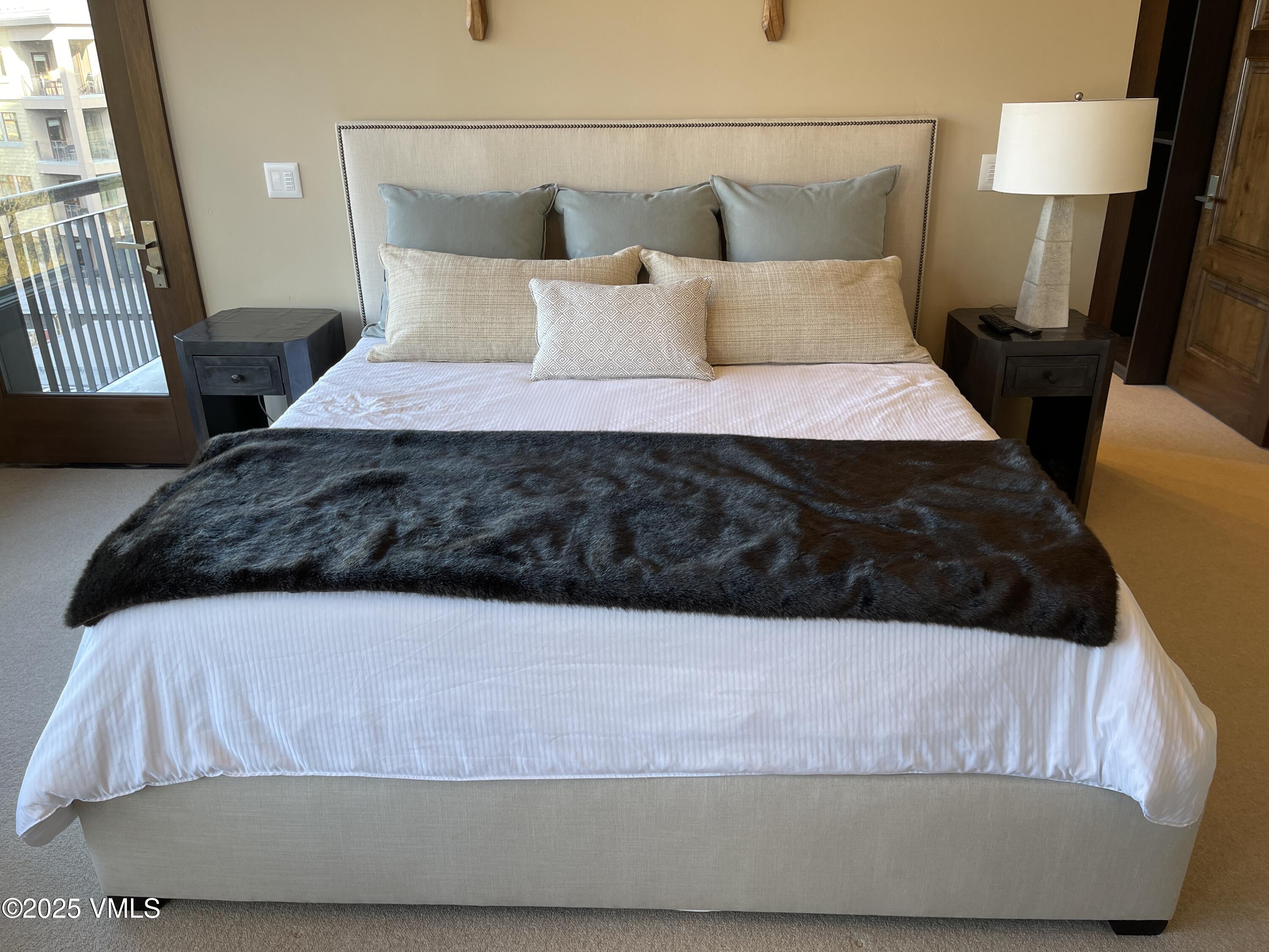 126 Riverfront Lane, Unit 510 Avon, CO 81620 - Photo 16 of 54 a large bed sitting in a bedroom next to a lamp