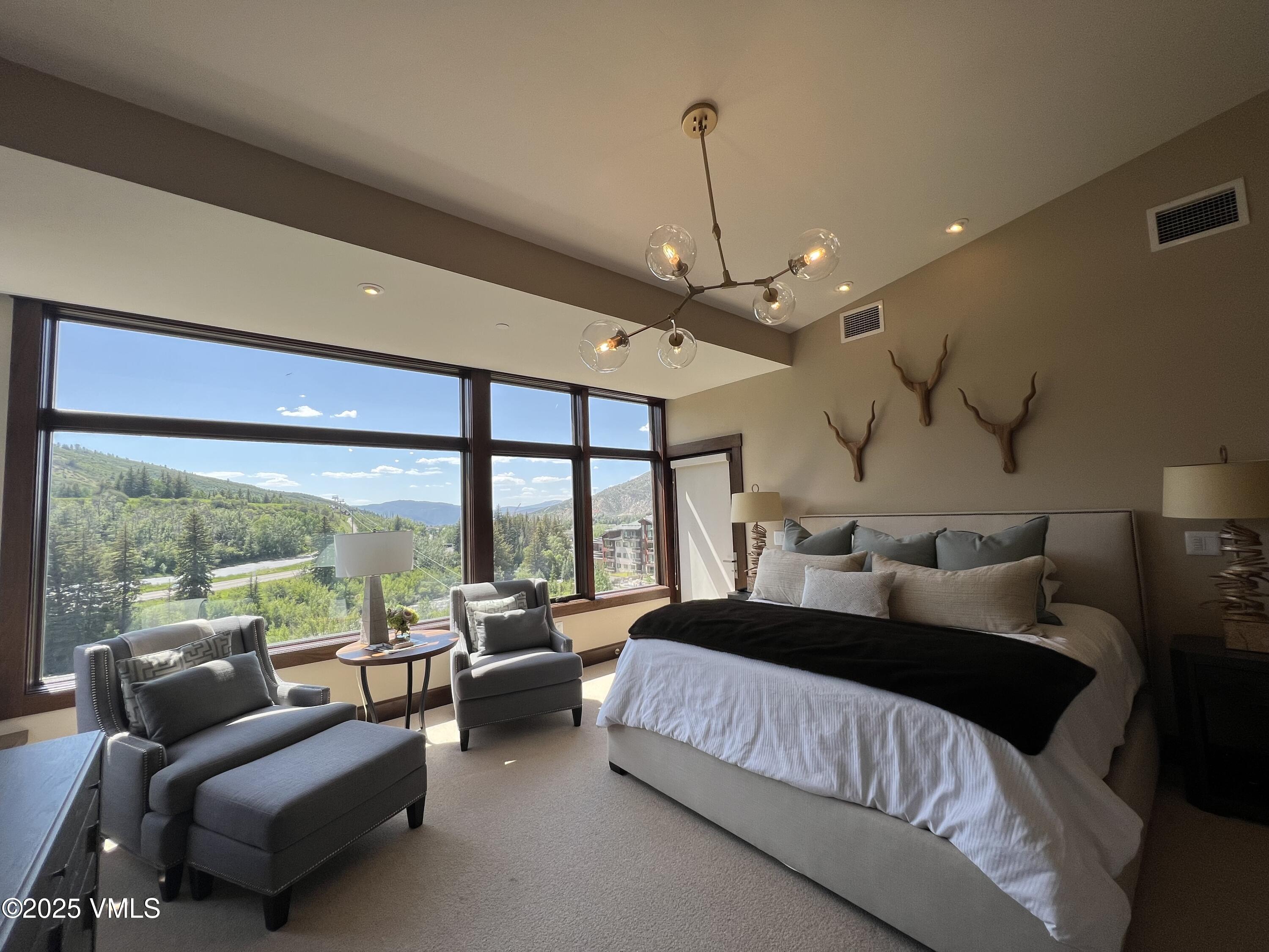 126 Riverfront Lane, Unit 510 Avon, CO 81620 - Photo 17 of 54 a bedroom with a bed couch and large window