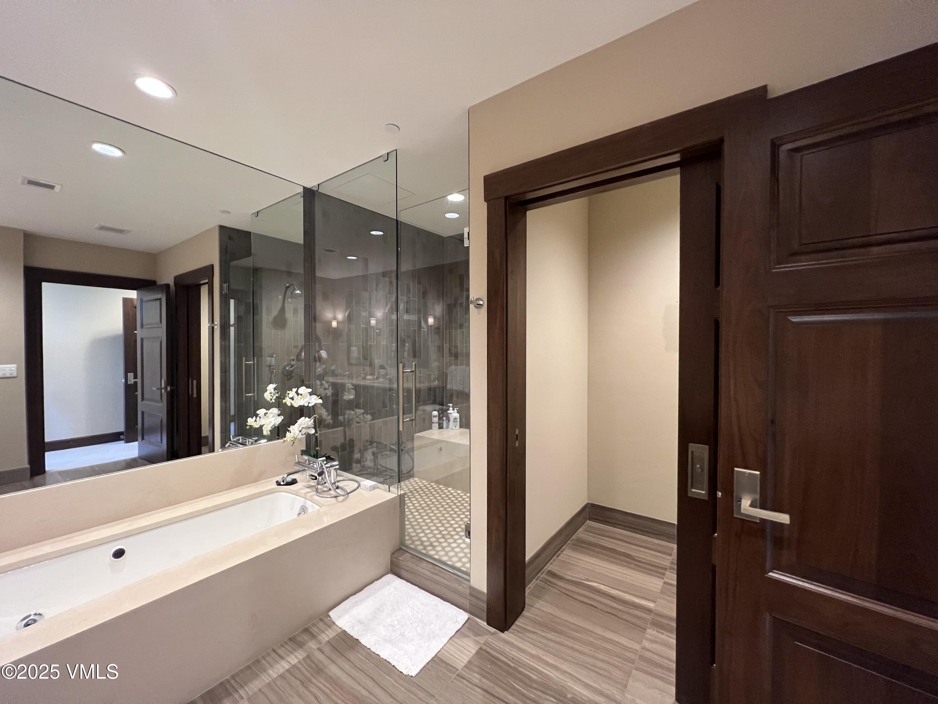126 Riverfront Lane, Unit 510 Avon, CO 81620 - Photo 28 of 54 a bathroom with a double vanity sink a mirror and a bathtub