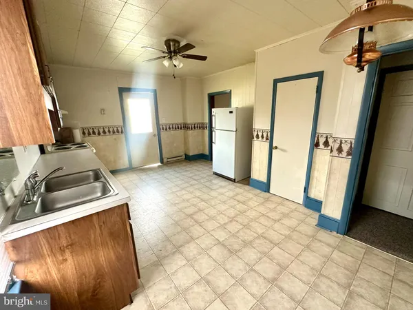 a view of a kitchen with fridge and wooden floor