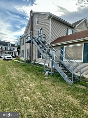 a backyard of a house with barbeque oven table and chairs