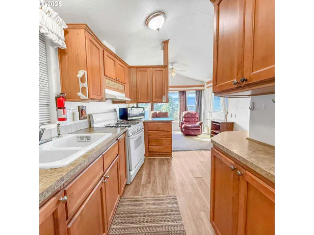 a kitchen with stainless steel appliances sink stove and cabinets