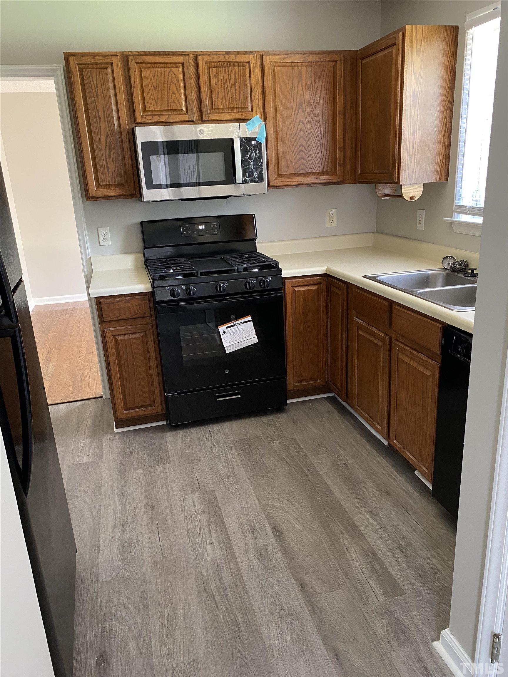 4433 Moss Spring Drive Raleigh, NC 27616 - Photo 17 of 25 a kitchen with stainless steel appliances granite countertop a stove a microwave a sink and cabinets