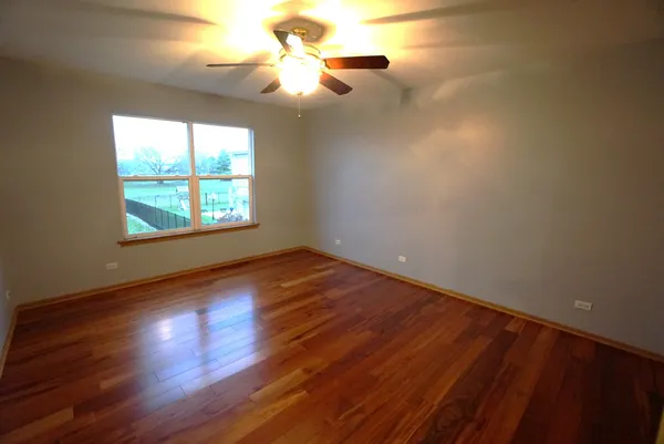 a view of empty room with window and wooden floor