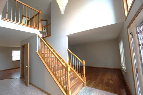 a view of staircase with railing and a window