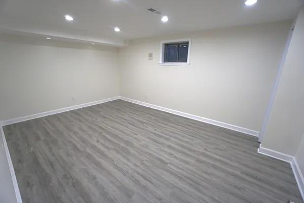 a view of an empty room with wooden floor