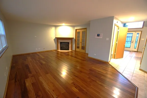 a view of empty room with wooden floor and fireplace