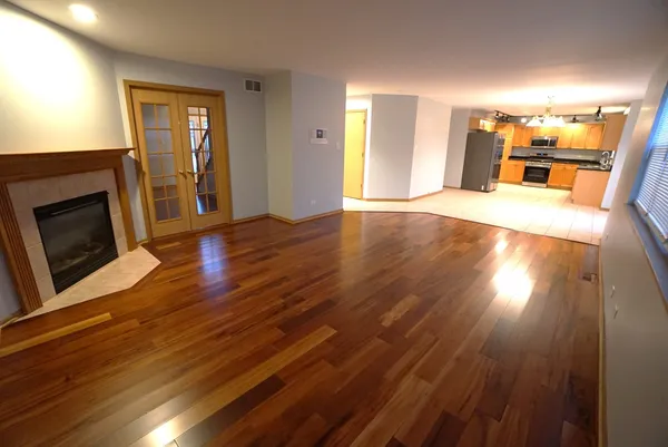 a view of a living room a dining room with wooden floor and a fireplace